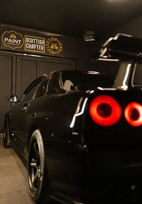 paint assassins, scottish chapter signs and a car parked inside a shop